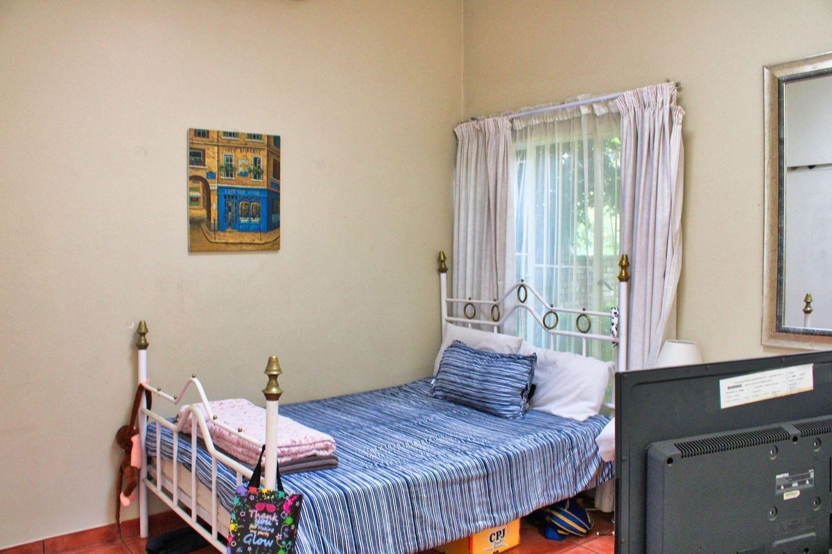 A standard bedroom featuring tiled flooring and window treatments, providing a functional living space.