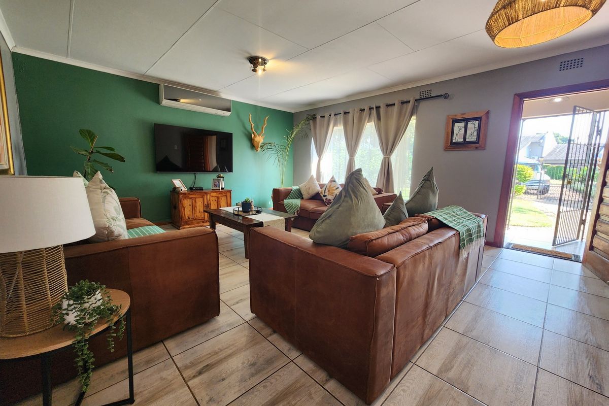 A comfortable living room featuring ceramic floor tiles, a split-system air conditioner, and direct access to the exterior through a security gate.