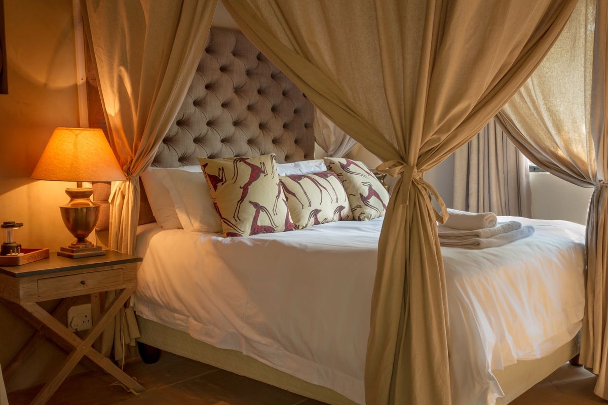 A cozy bedroom featuring a tufted headboard and a decorative canopy frame, creating a warm and inviting atmosphere.