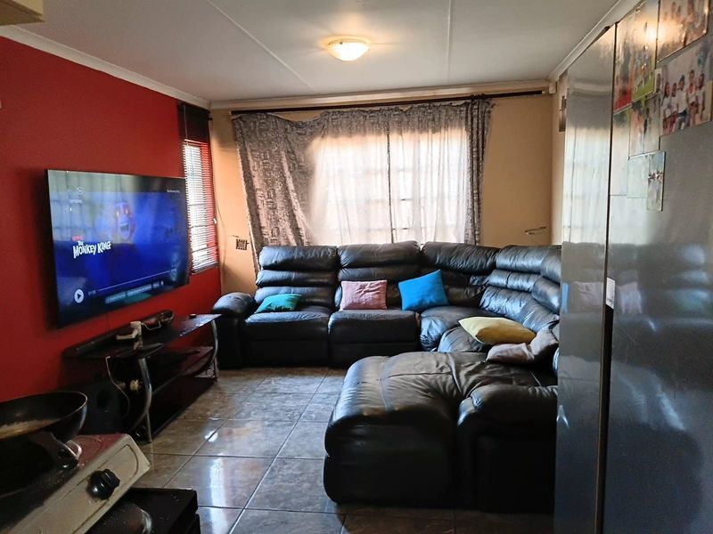 A functional living room featuring tiled flooring and a coved ceiling, providing a comfortable space for relaxation and entertainment.