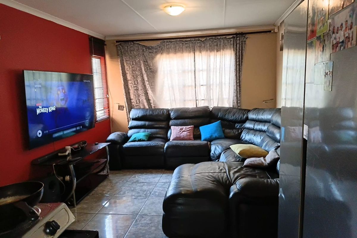 A functional living room featuring tiled flooring and a coved ceiling, providing a comfortable space for relaxation and entertainment.