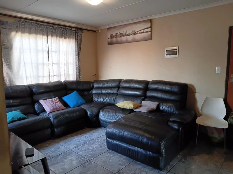 A living room featuring tiled flooring and neutral wall tones, providing a functional space for relaxation.