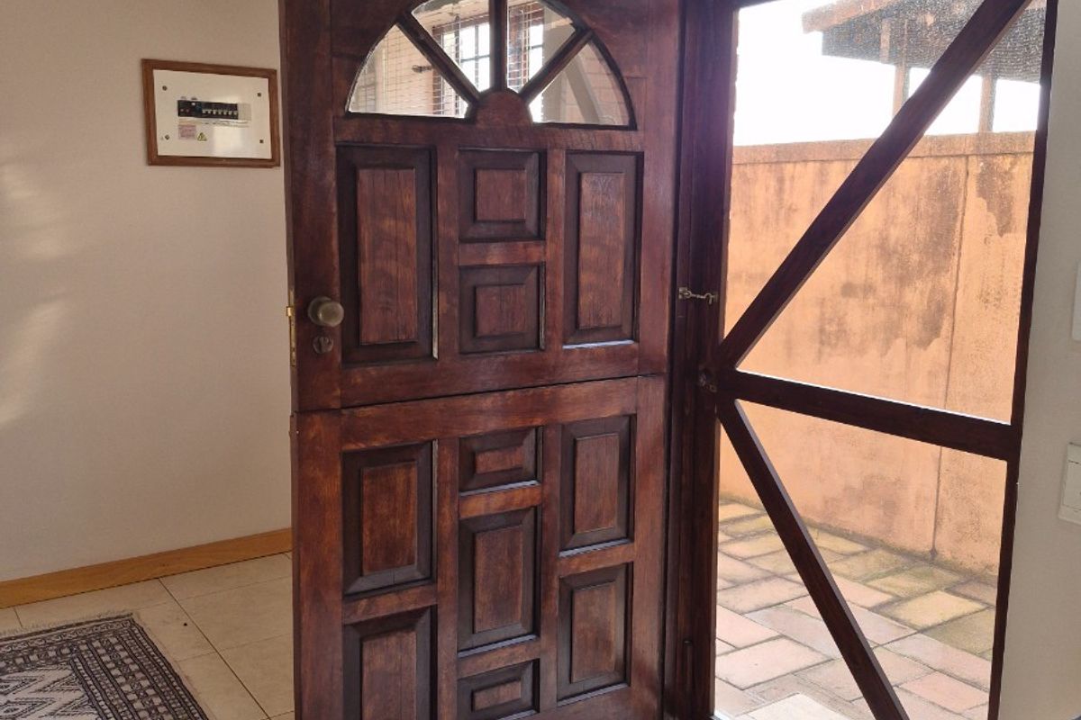 Entryway featuring a traditional wooden stable-style door with glass detailing, opening onto a paved outdoor area.