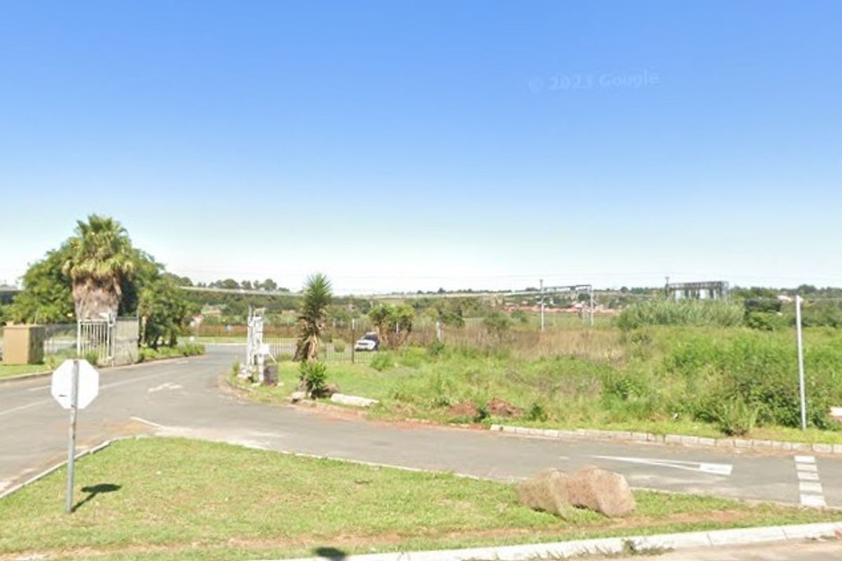 A street-level view of the vacant agricultural land, showing the road access and surrounding landscape.