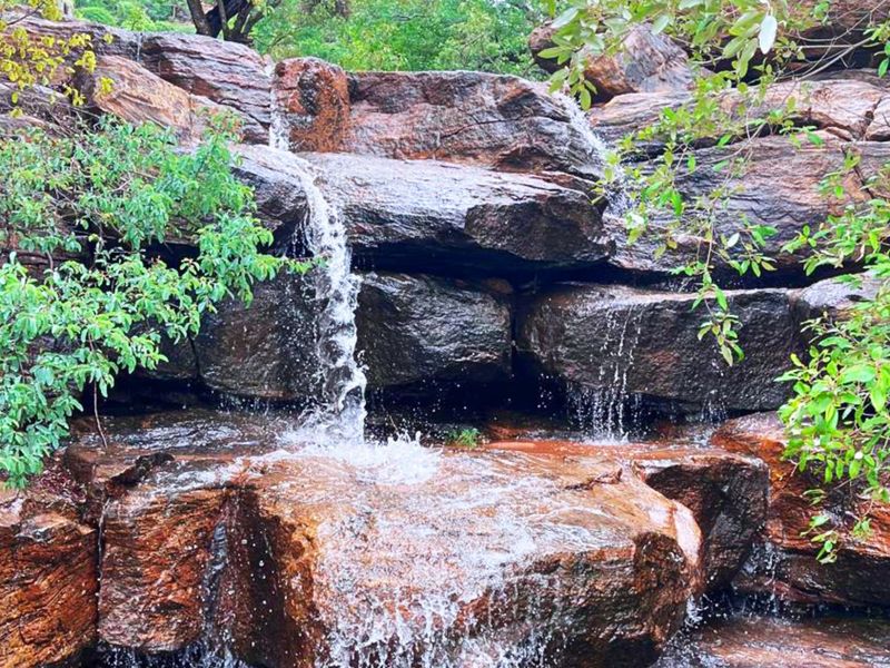 A scenic view of a natural rock waterfall feature located on the farm property.