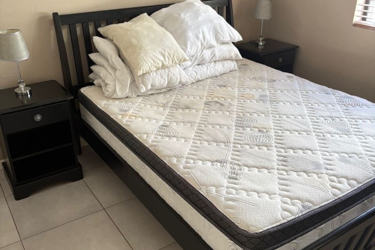 A standard bedroom featuring neutral wall paint and tiled flooring, providing a functional and simple living space.