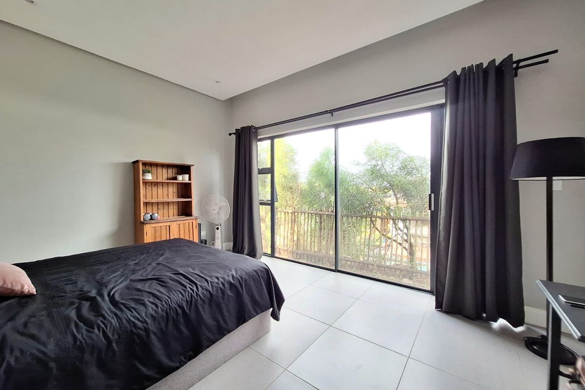Spacious bedroom featuring large sliding glass doors that provide natural light and access to an outdoor balcony area.