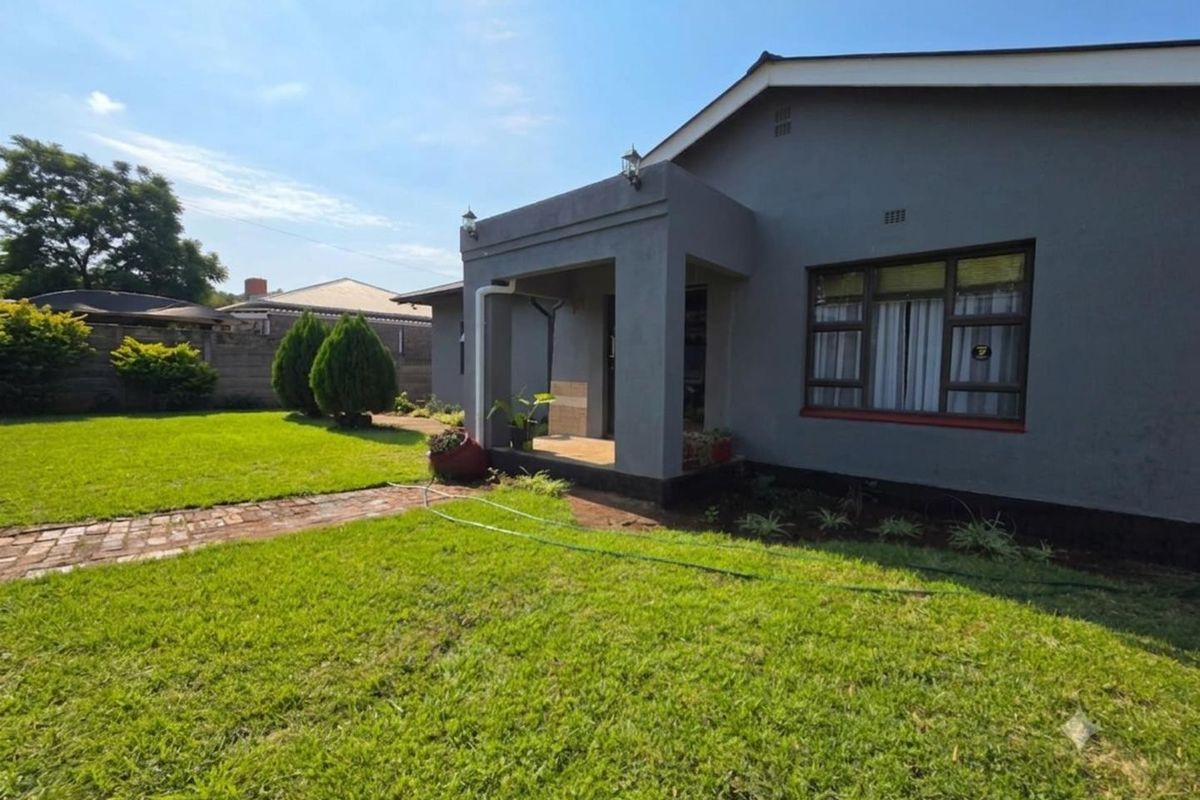 A well-maintained exterior view of the house featuring a covered entrance porch, brick pathway, and a neatly landscaped lawn.