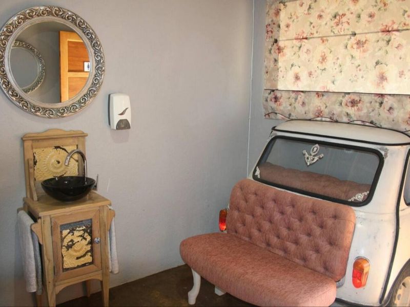 A uniquely styled bathroom featuring a vessel sink vanity and decorative wall-mounted elements.