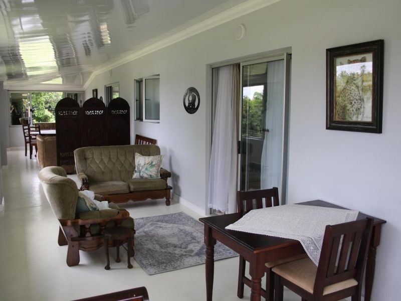 A spacious, enclosed patio area featuring tiled flooring, a glossy ceiling, and sliding glass doors providing access to the exterior.
