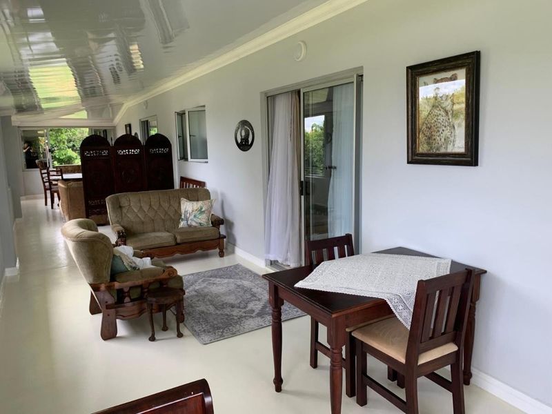 A covered patio area featuring tiled flooring, a glossy ceiling finish, and sliding glass doors providing access to the interior living space.