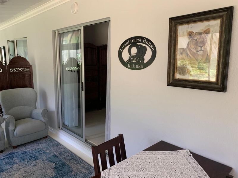 A covered patio area featuring a sliding glass door entrance, neutral wall finishes, and decorative cornice detailing.