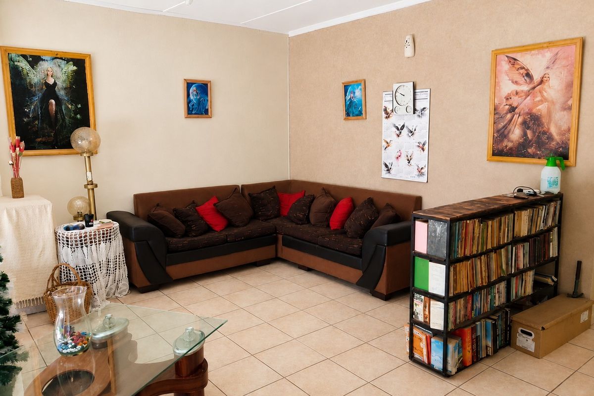 A living room featuring neutral wall finishes and ceramic floor tiles, providing a functional and well-lit space for relaxation.