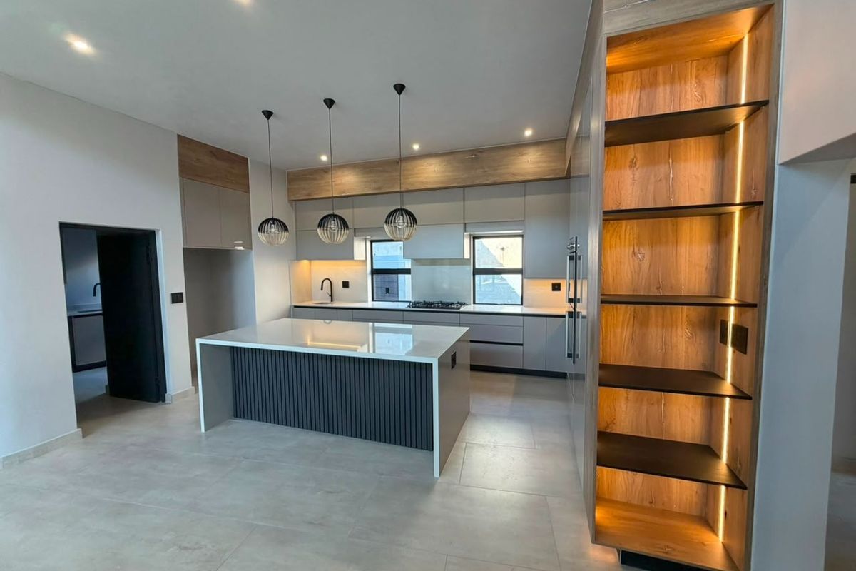 Modern kitchen featuring a central island, sleek cabinetry, integrated lighting, and high-quality finishes, offering a contemporary and functional culinary space.