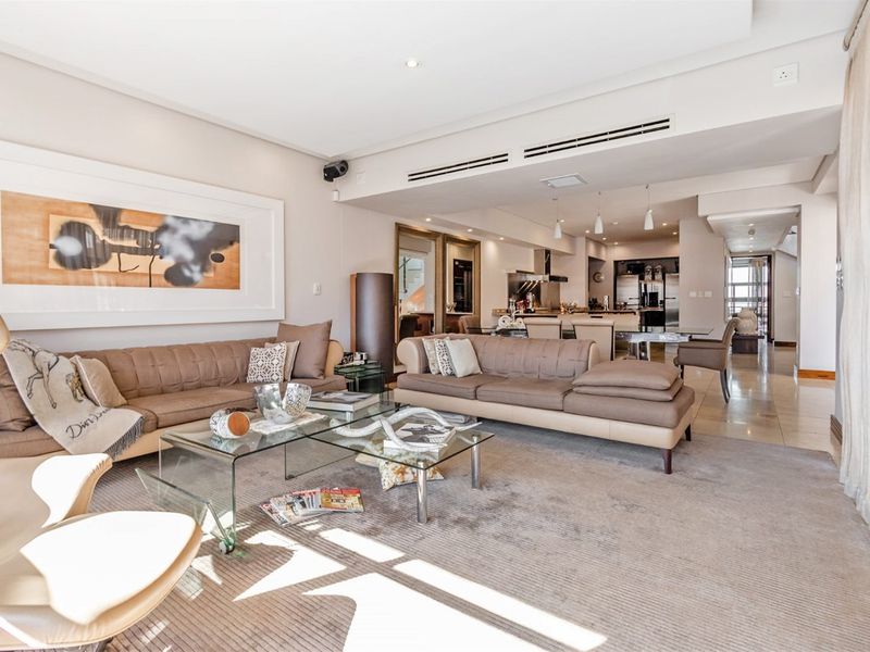 Spacious open-plan living and dining area featuring ducted air conditioning, recessed lighting, and a seamless transition to a modern integrated kitchen.