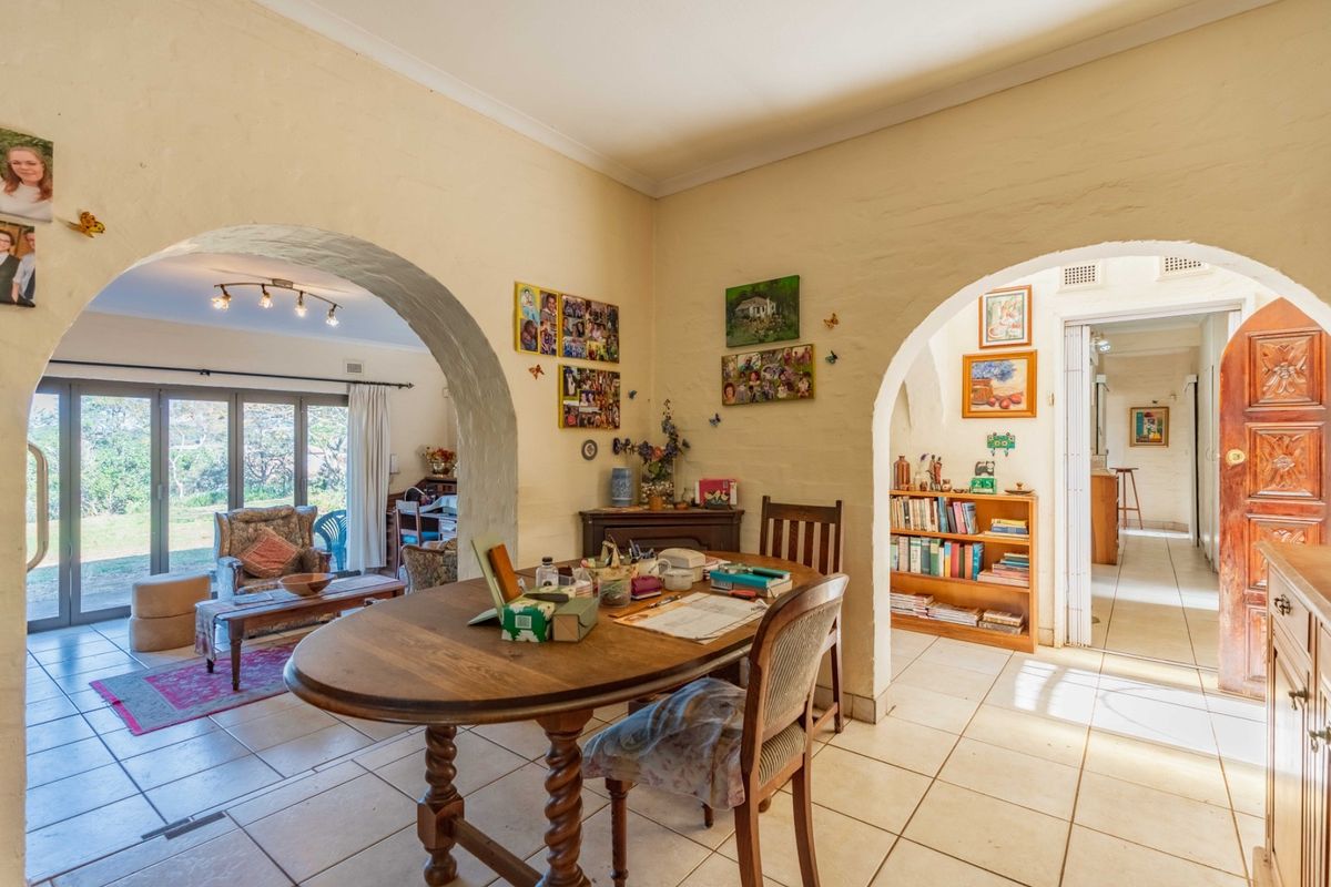 Open plan dining area featuring distinctive arched doorways, ceramic floor tiles, and seamless flow into the adjacent living space and entryway.