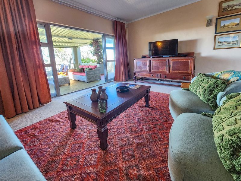A comfortable living room featuring large sliding glass doors that open onto a covered patio, providing seamless indoor-outdoor flow and natural light.