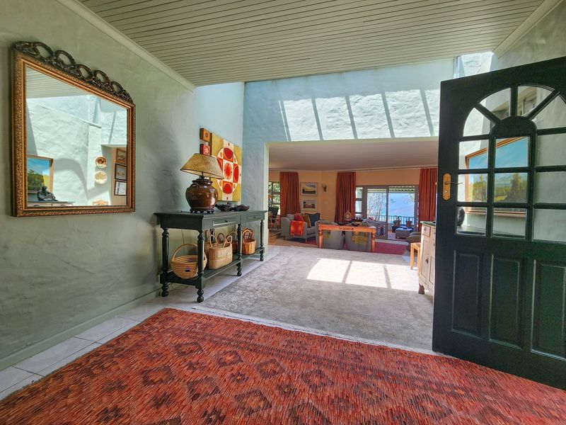 Welcoming entrance foyer featuring textured walls, high ceilings, and a seamless transition into the open-plan living area with views beyond.