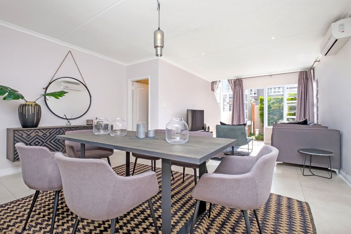 Open-plan living and dining area featuring tiled flooring, recessed ceiling lighting, and sliding glass doors providing access to the outdoor patio space.