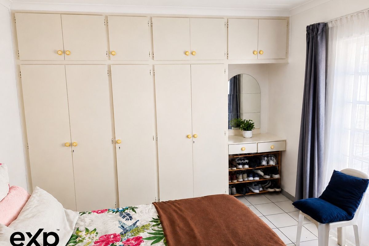 Bedroom featuring extensive built-in floor-to-ceiling cabinetry with integrated vanity and mirror, providing ample storage space.