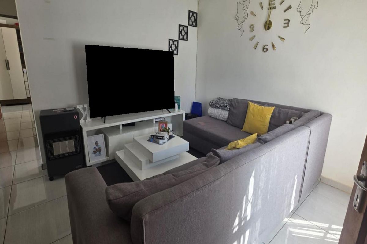 A comfortable living room featuring tiled flooring and a neutral layout, providing a functional space for relaxation and entertainment.