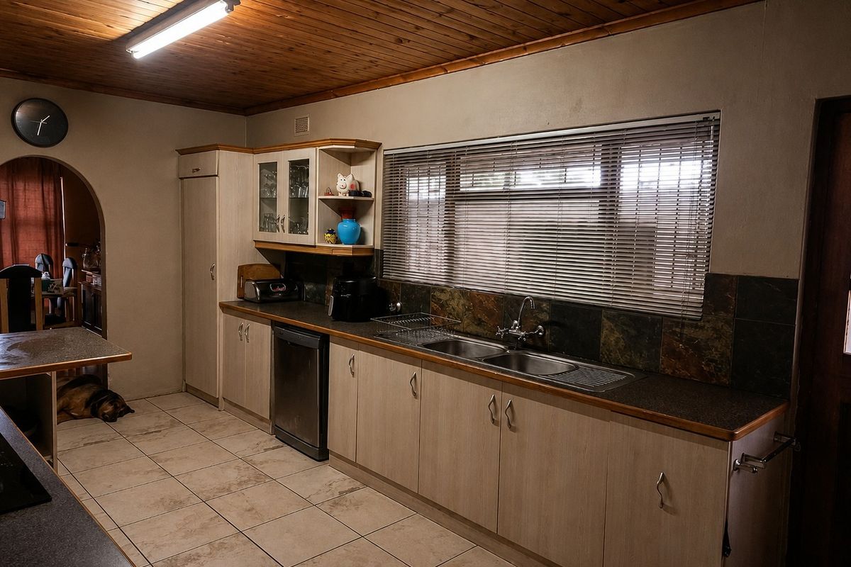 Functional kitchen featuring timber ceiling, laminate cabinetry, double bowl stainless steel sink, and slate tile splashback with ceramic floor tiles.
