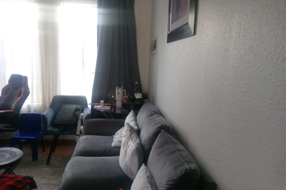 A living room area featuring large windows that allow for natural light, providing a comfortable space for relaxation.