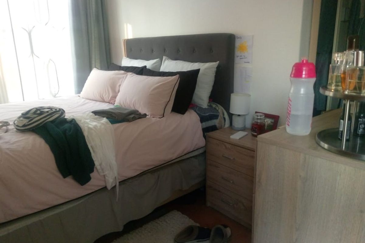 A bedroom featuring a window with curtains and neutral wall finishes.