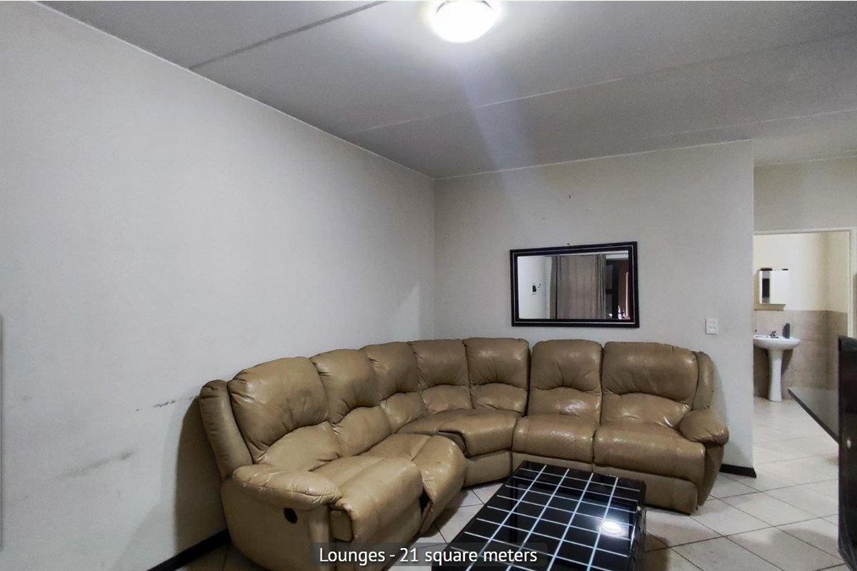 A 21 square meter lounge area featuring tiled flooring and a neutral wall finish, providing a functional living space.