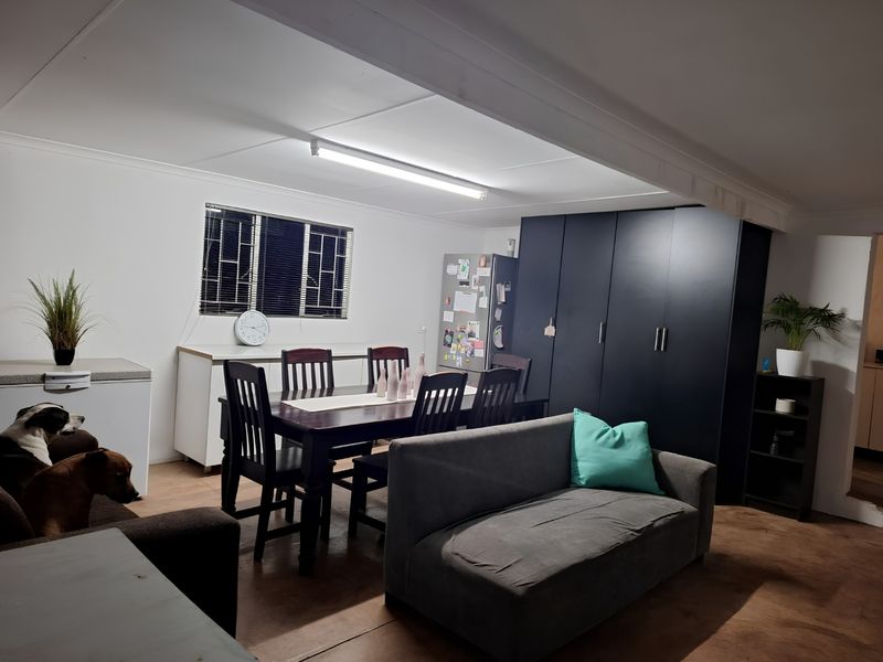Open plan living and dining area featuring built-in cabinetry and security bars on the window.