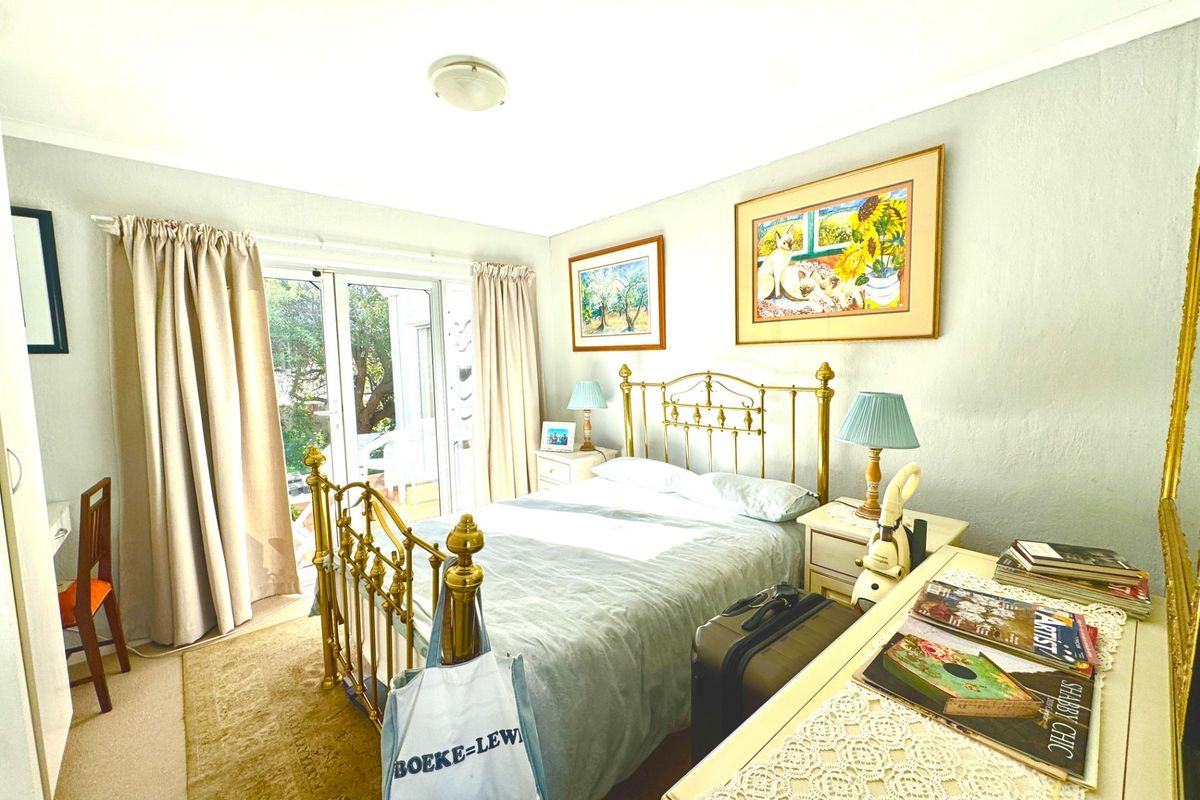 A well-lit bedroom featuring carpeted flooring and a sliding glass door providing direct access to an outdoor area.
