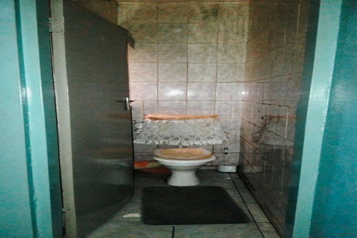 A compact bathroom featuring tiled walls and flooring, equipped with a standard toilet fixture.