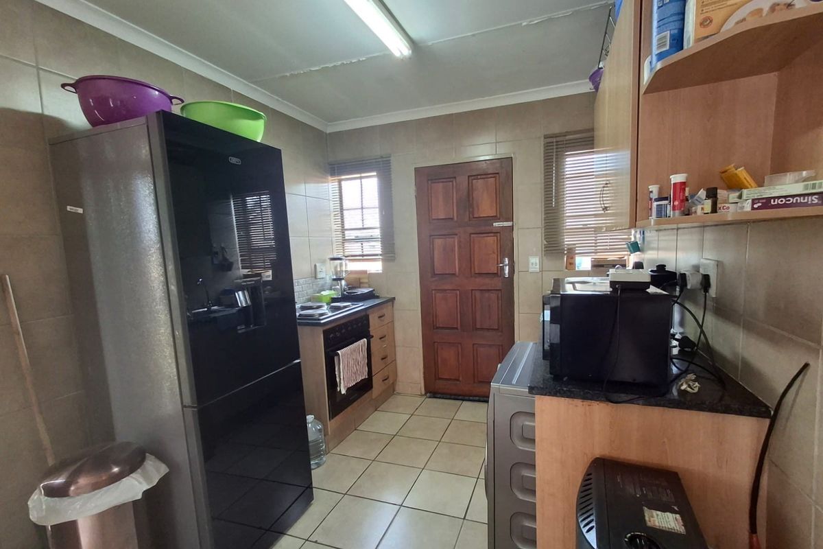 A functional kitchen featuring tiled walls and flooring, built-in cabinetry, and a built-in oven with hob, providing a practical workspace.