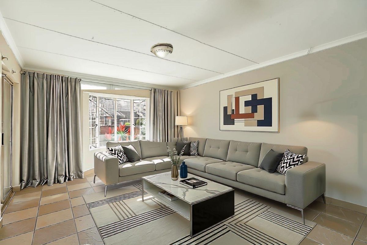 A comfortable living room featuring tiled flooring and large windows that provide natural light, creating a welcoming space for relaxation.