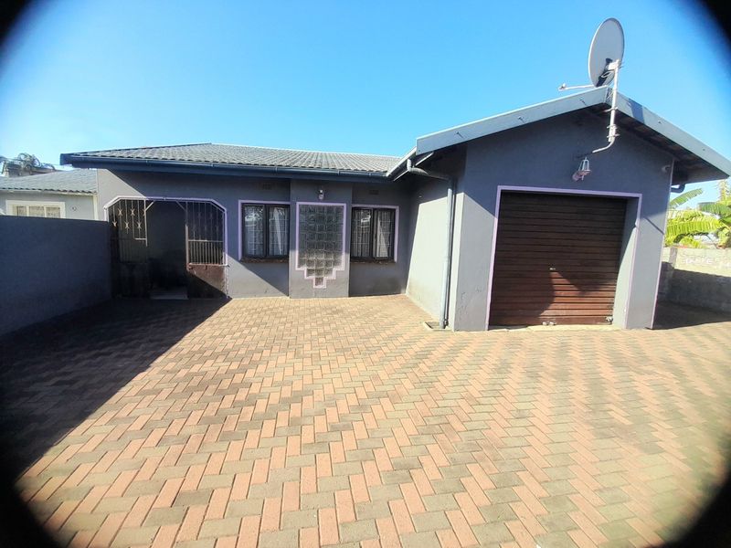 Front exterior view of the property featuring a paved driveway, single garage, and secure entrance with decorative glass block detailing.