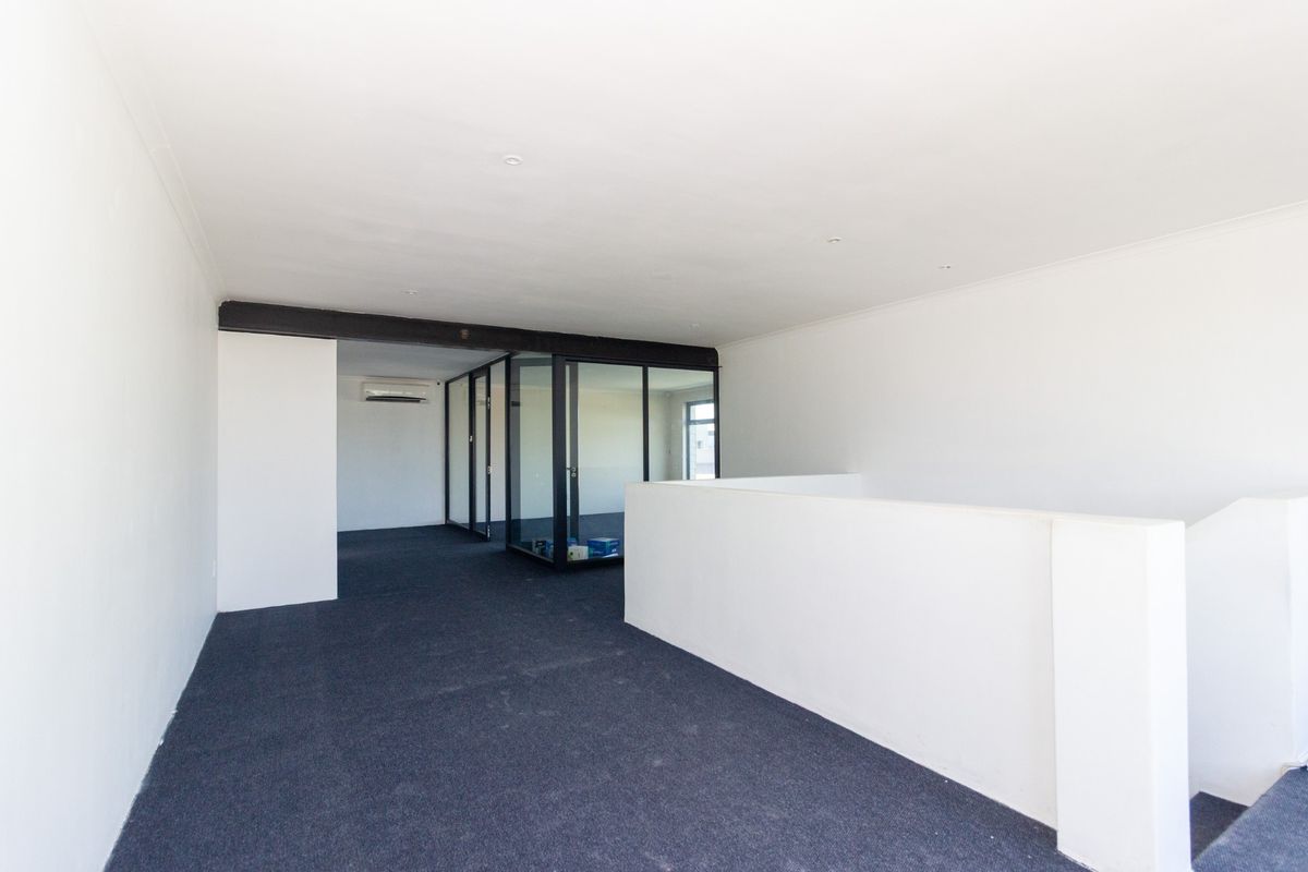 A bright, open-plan office space featuring modern glass partitions, neutral finishes, and a split-system air conditioning unit, ready for professional fit-out.