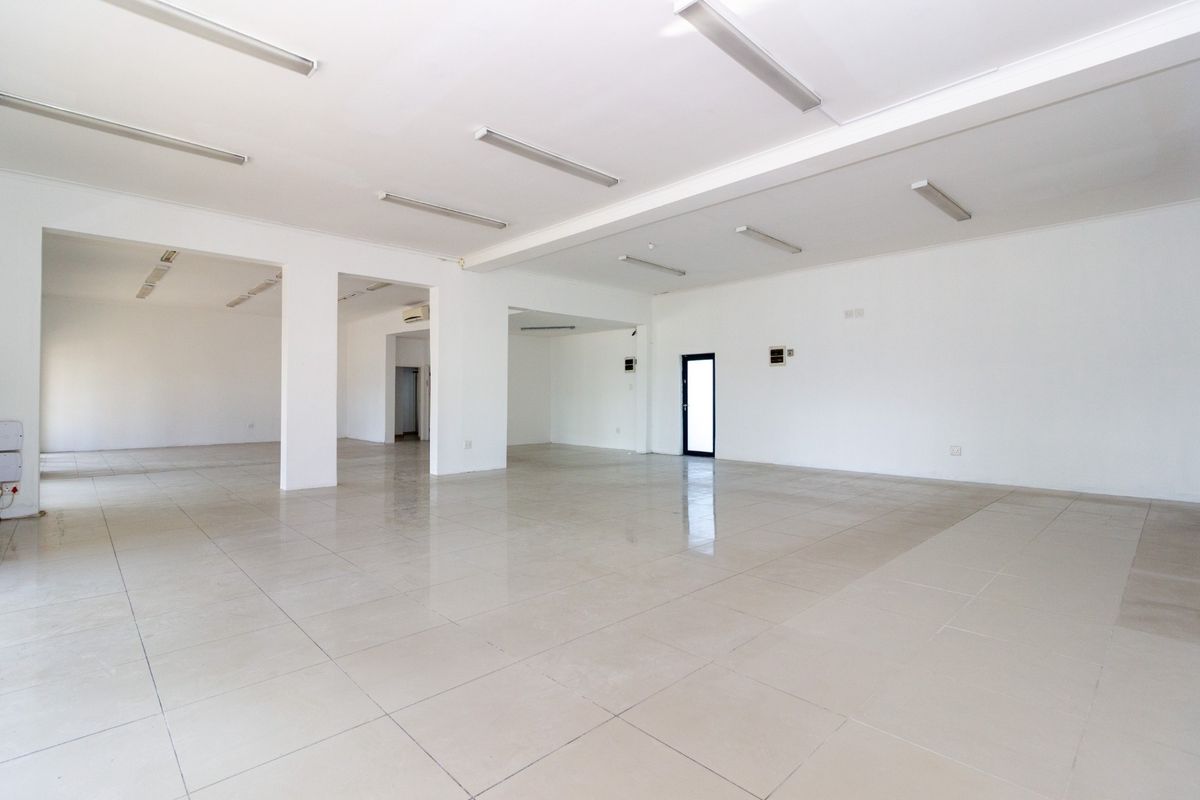 Spacious open-plan retail area featuring neutral tiled flooring, bright overhead lighting, and a clean, versatile layout suitable for various commercial uses.