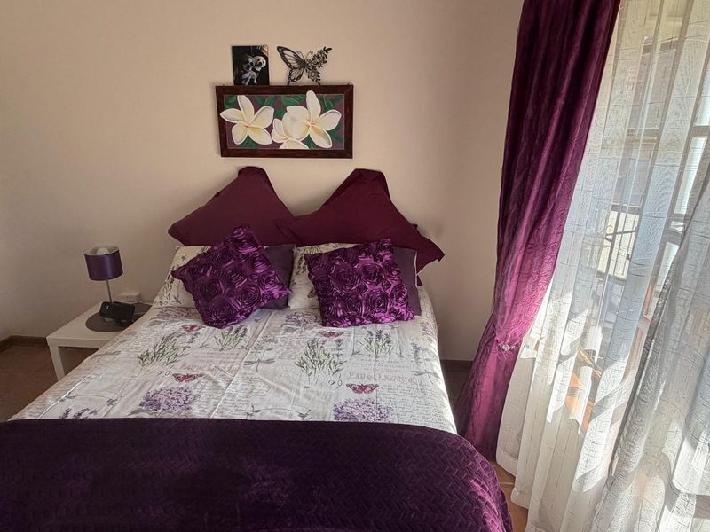 A cozy bedroom featuring tiled flooring and a sliding glass door providing access to an outdoor area.