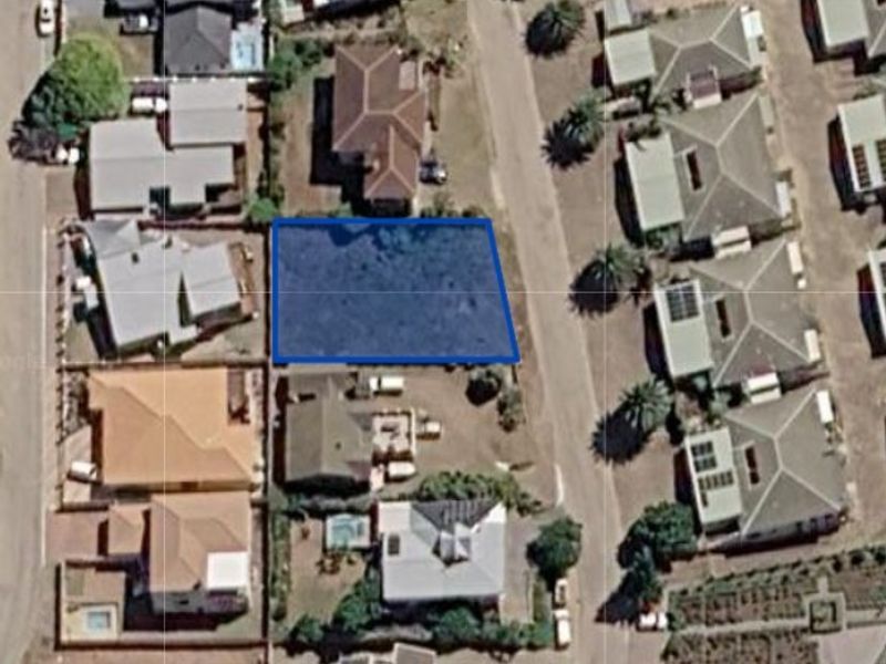 An aerial view of a vacant residential land parcel situated within an established suburban neighborhood.