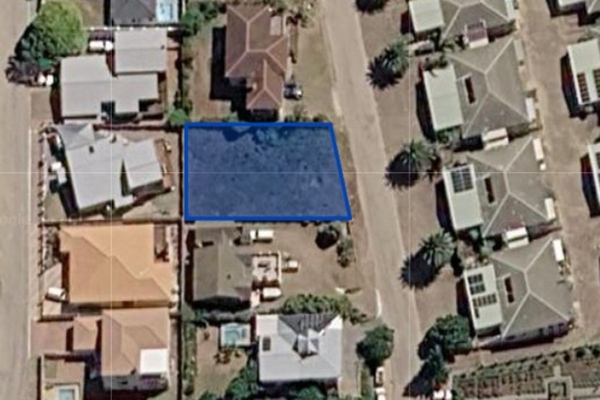 An aerial view of a vacant residential land parcel situated within an established suburban neighborhood.