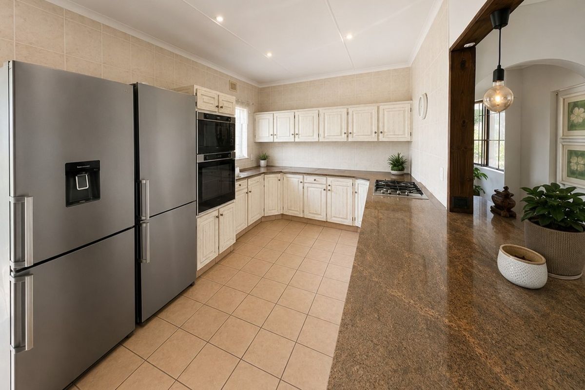 A well-maintained kitchen featuring light-toned cabinetry, granite countertops, a gas cooktop, and built-in appliances with tiled flooring and recessed lighting.