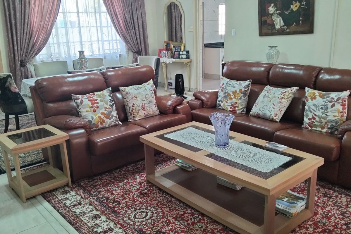 A comfortable living room area featuring tiled flooring and an open-plan layout that flows into the adjacent dining space.