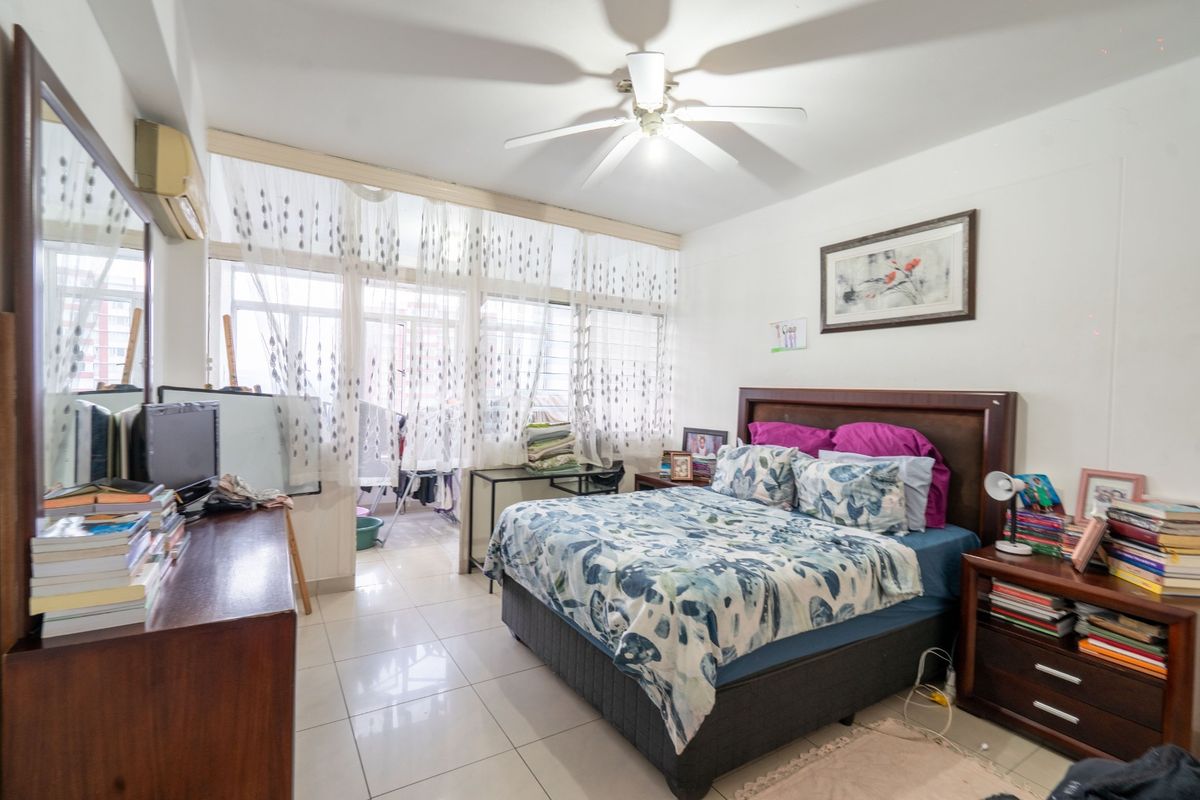 A bedroom featuring tiled flooring, a ceiling fan, and a split-system air conditioner, with sliding glass doors leading to an adjacent balcony area.