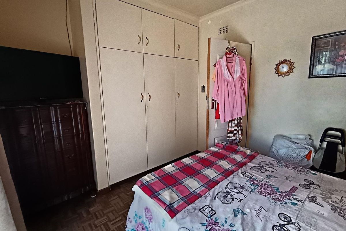 A bedroom featuring built-in cupboards and parquet flooring.