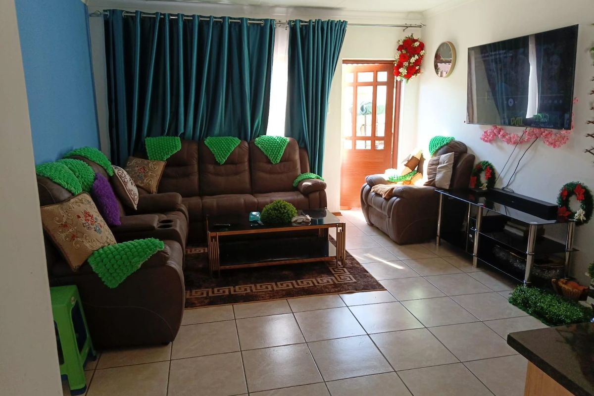 A living room featuring tiled flooring and a glass-paneled exterior door, providing access to the outdoor area.