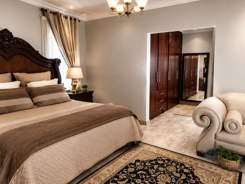 Spacious bedroom featuring built-in wooden cupboards, tiled flooring, and elegant recessed lighting, offering a comfortable and well-maintained living space.