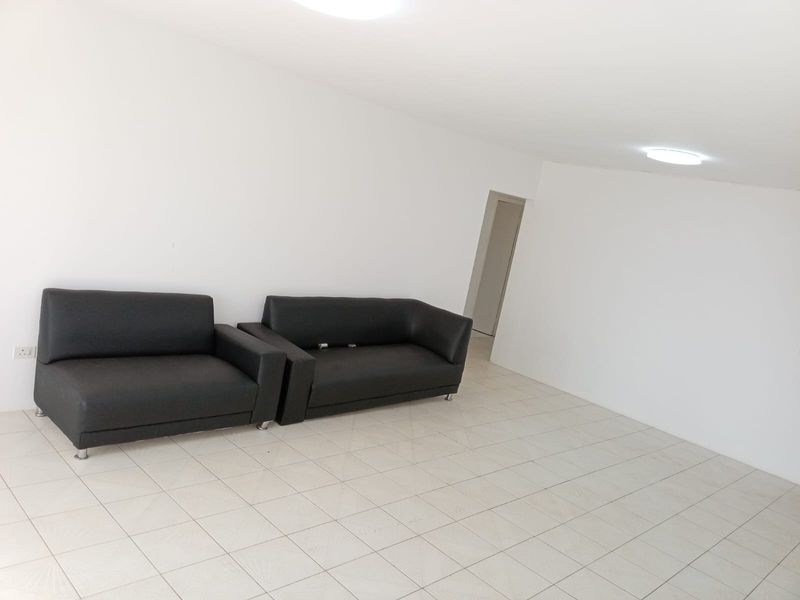 A simple, open-plan living area featuring neutral tiled flooring and basic ceiling lighting, providing a blank canvas for interior design.