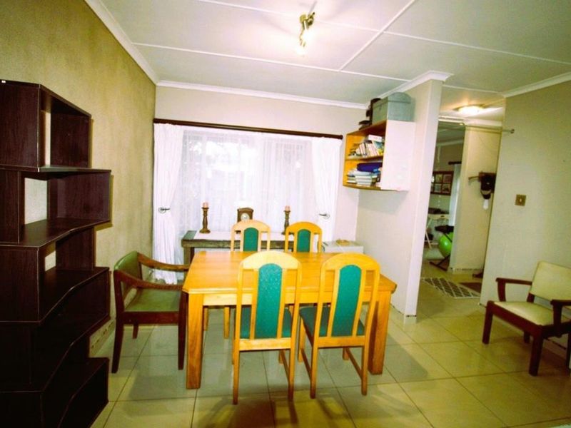 A functional dining room area featuring tiled flooring and neutral wall finishes, providing a practical space for family meals and gatherings.