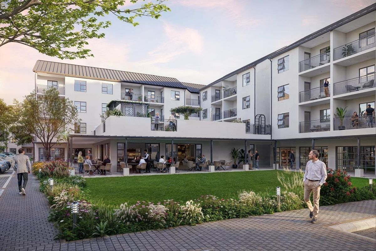 A well-maintained retirement village courtyard featuring a landscaped garden, paved walkways, and a covered patio area for residents.