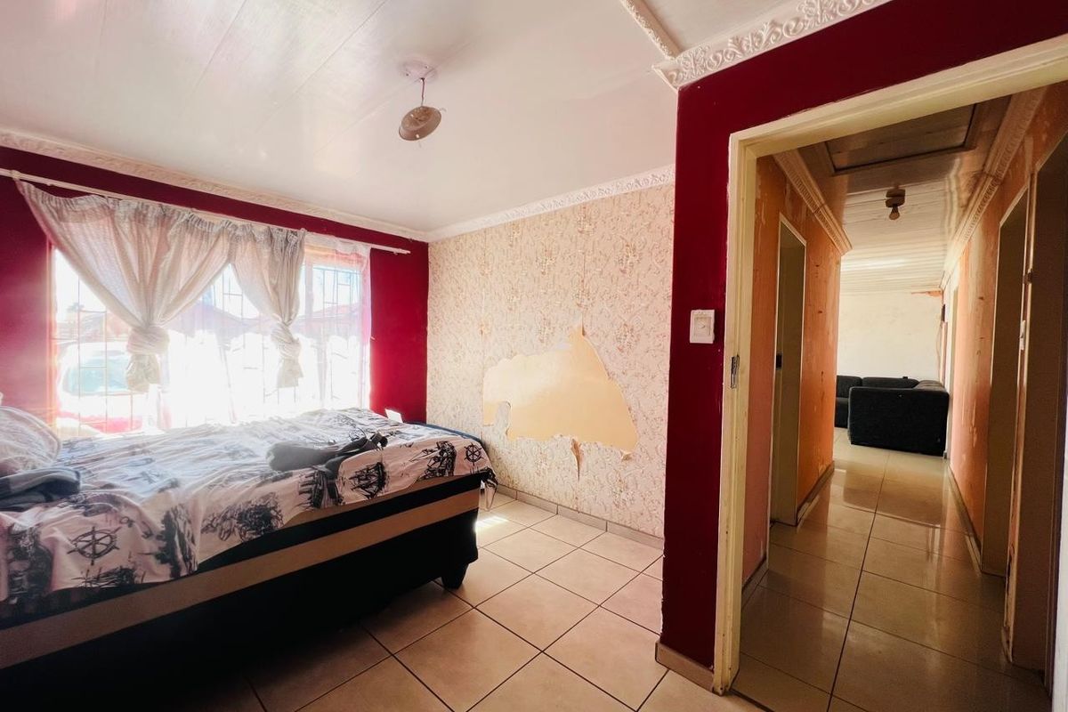 Bedroom featuring tiled flooring and decorative ceiling cornice, currently requiring cosmetic updates to the wall finishes.